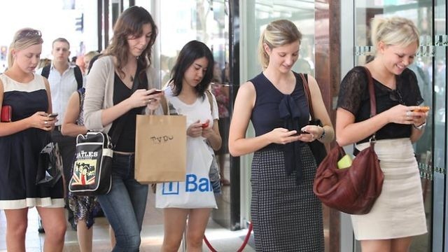 Resultado de imagen de El cualquier calle de una gran ciudad, los jóvenes caminan con el móvil en la mano