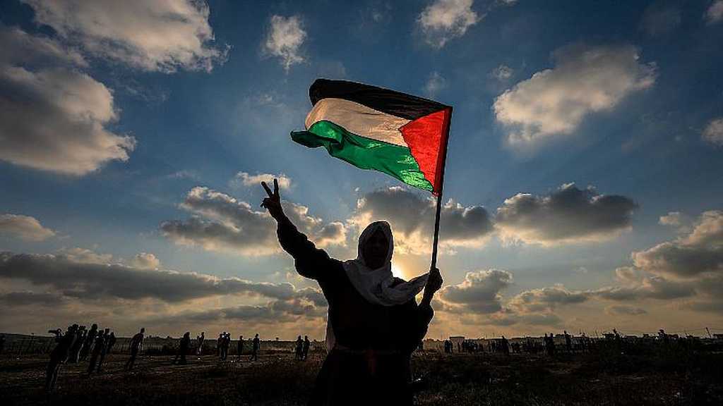 Un palestino enarbola una bandera en la zona ocupada,