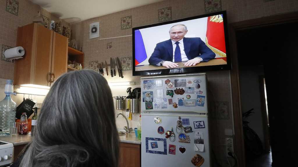 Una mujer se informa en la televisión sobre las noticias sobre Rusia.