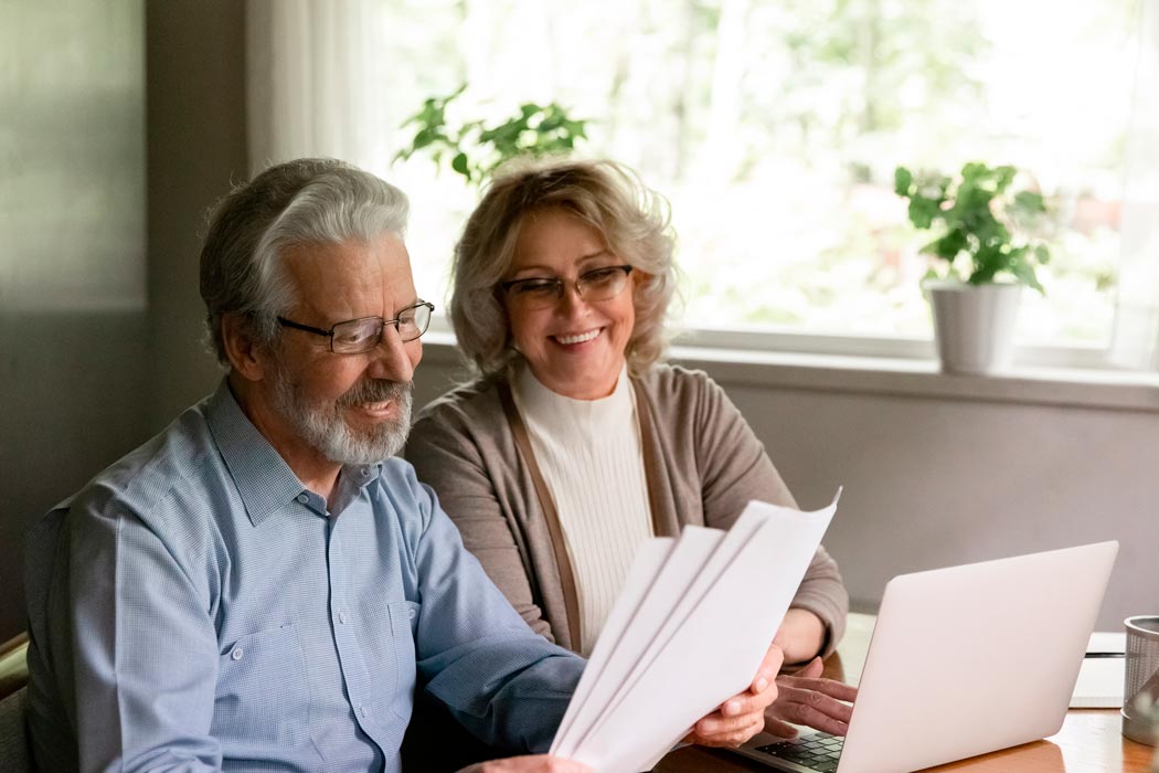 Una pareja de personas de edad avanzada leyendo planes de pensiones